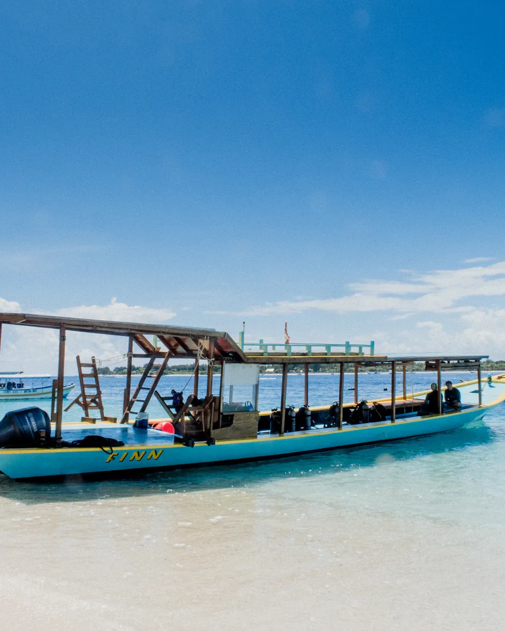 Local boat resting in glassy shallow water off a quiet Lombok beach