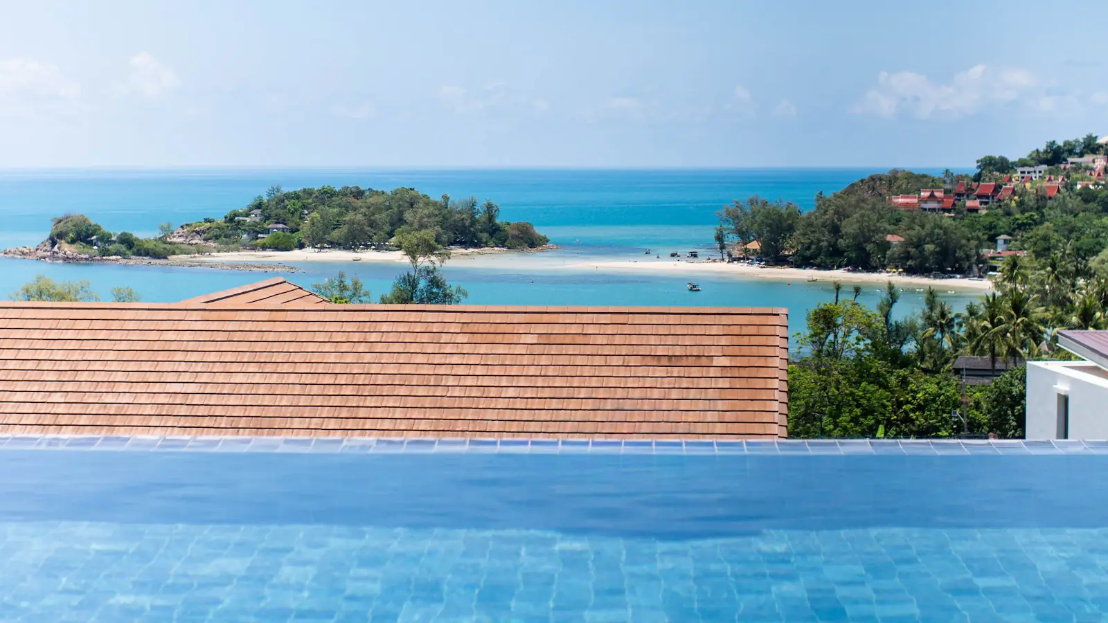 Infinity pool looking out over a turquoise bay and headland in Lombok