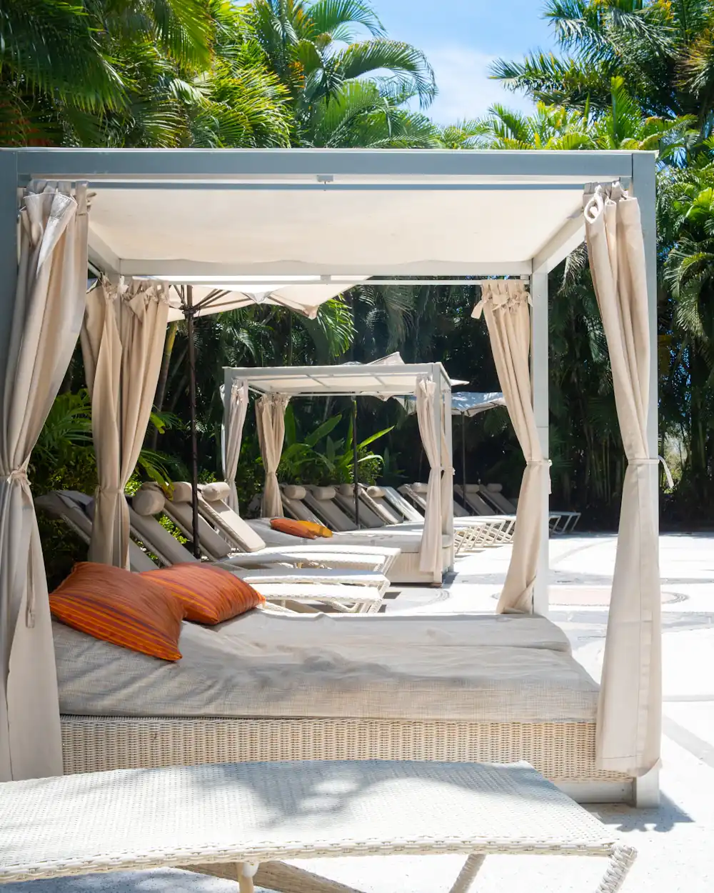 Shaded daybeds and cabanas beside a pool