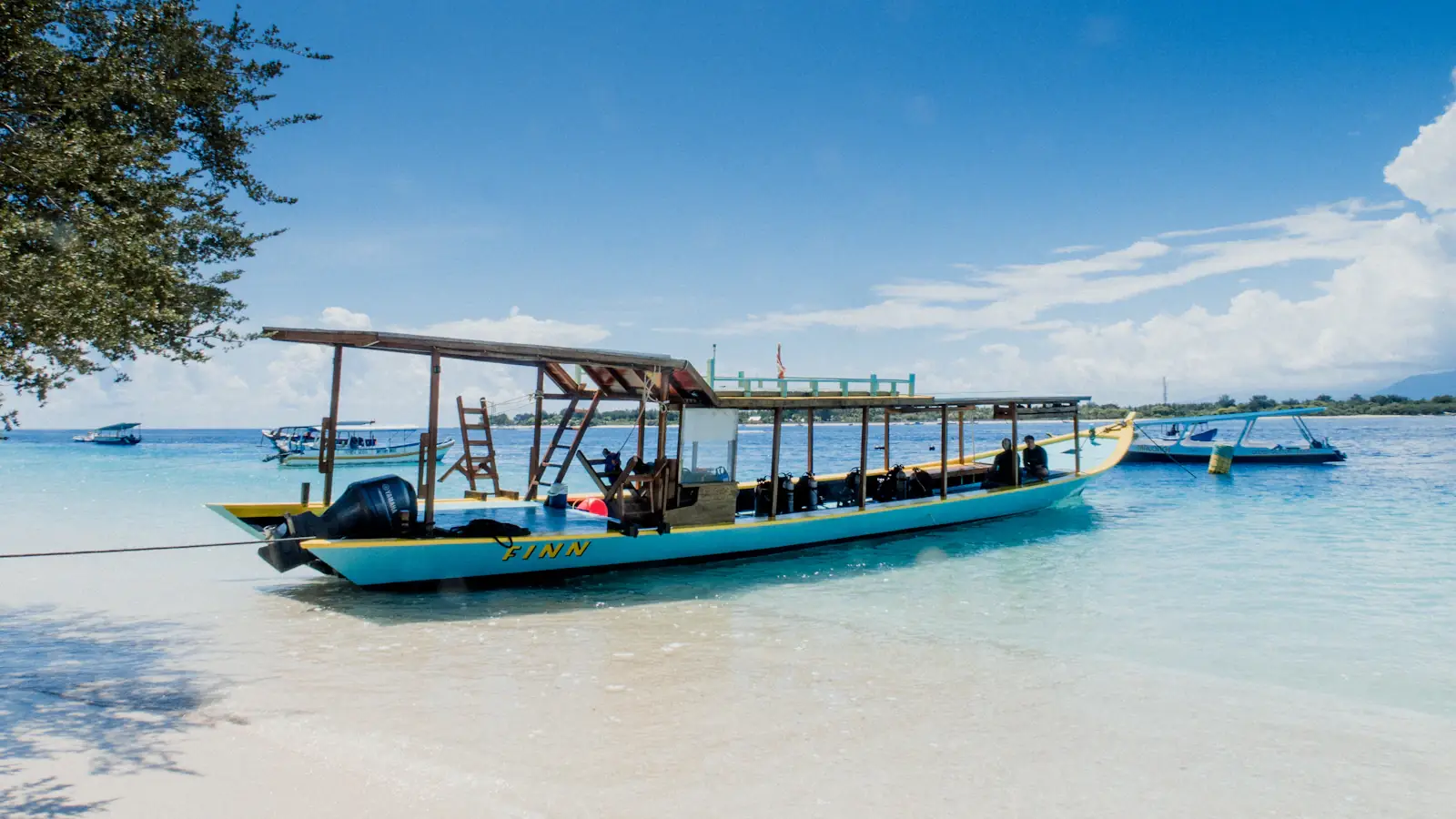 Boat resting in glassy shallow water off a beach