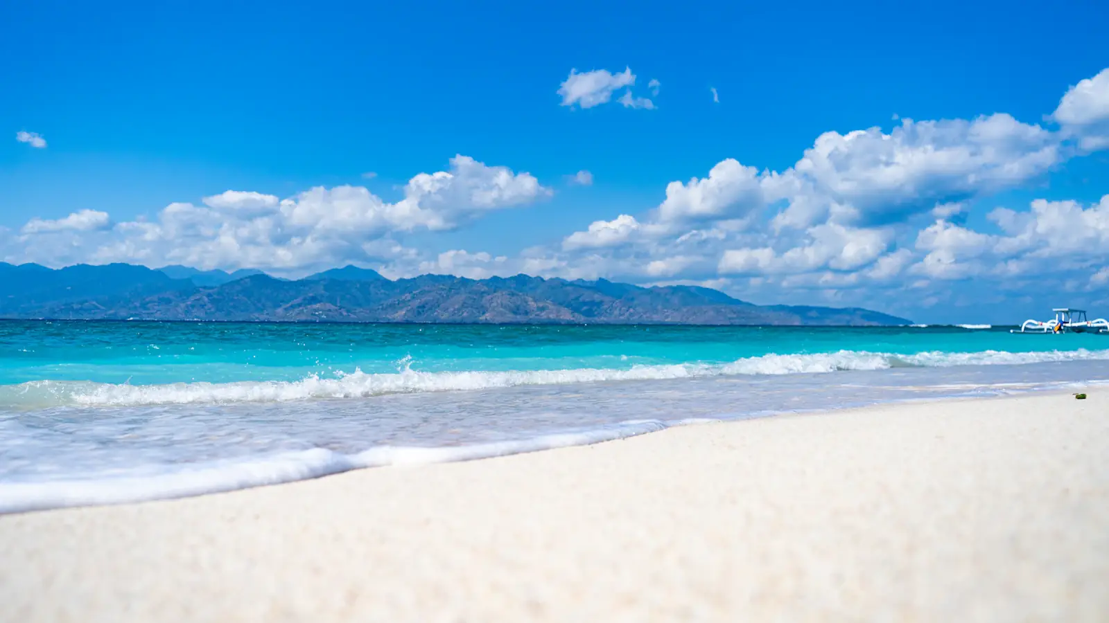 Wooden boat moored off a white-sand beach