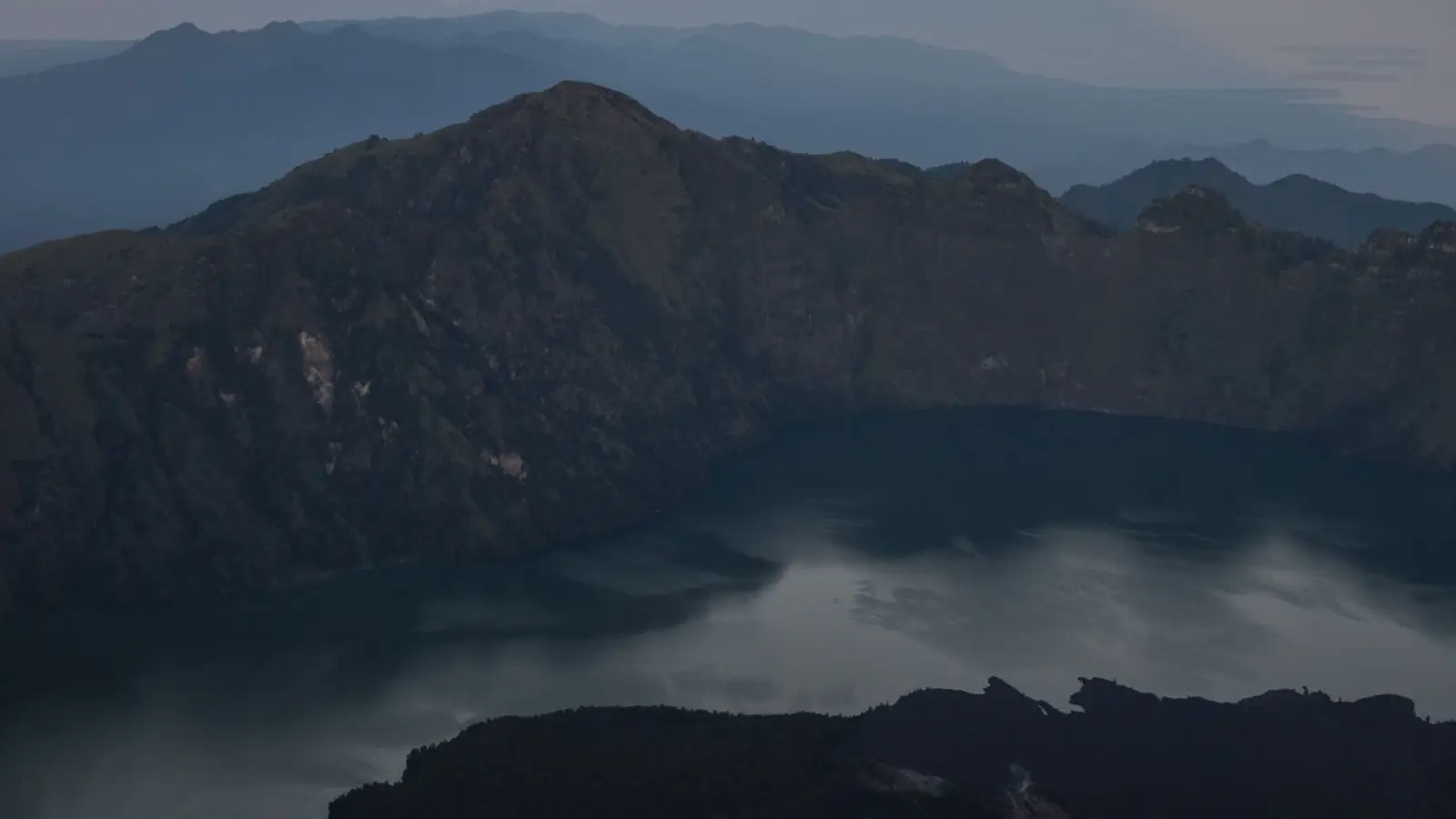 Sunrise over the Rinjani caldera, the summit shadow falling across the crater lake