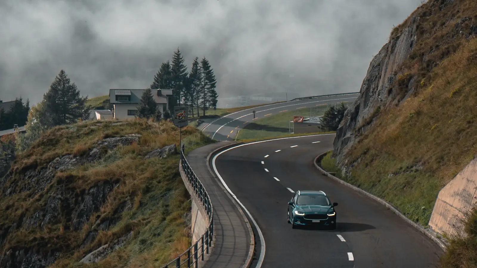 Coastal road curving along a green headland