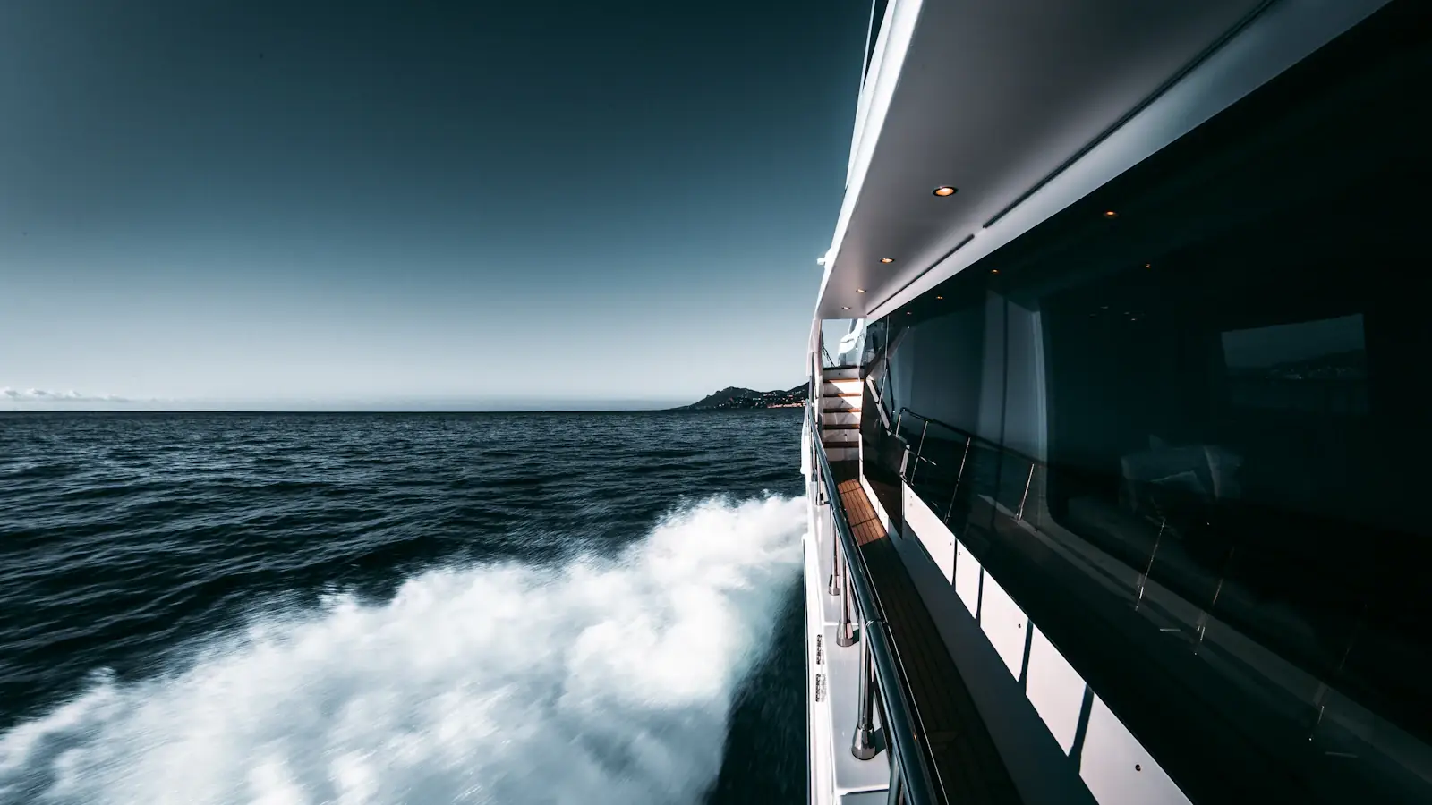 White motor yacht hull cutting through open water