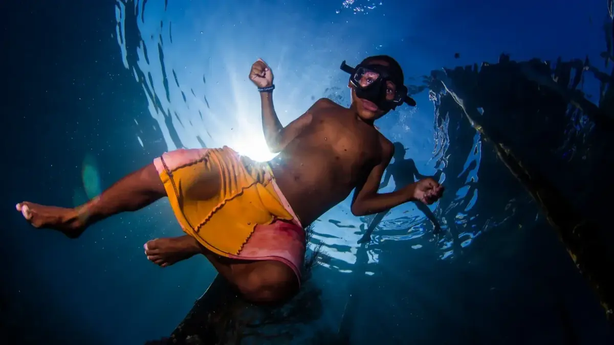 Freediver descending along a line in deep blue water