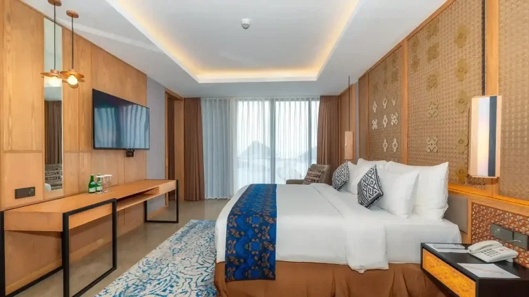 Hotel room with a made-up bed, desk and warm lighting