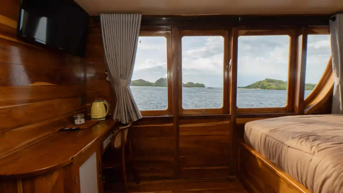 Guest cabin aboard a phinisi, timber panelling and made-up beds