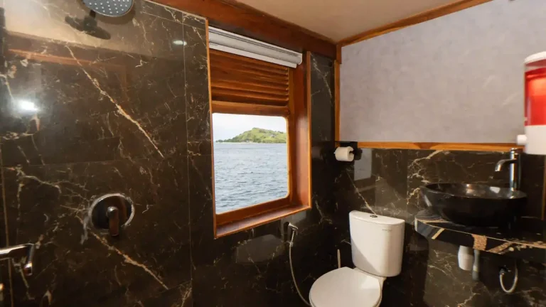Guest cabin aboard a phinisi, timber panelling and made-up beds
