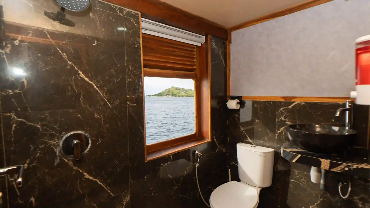 Guest cabin aboard a phinisi, timber panelling and made-up beds
