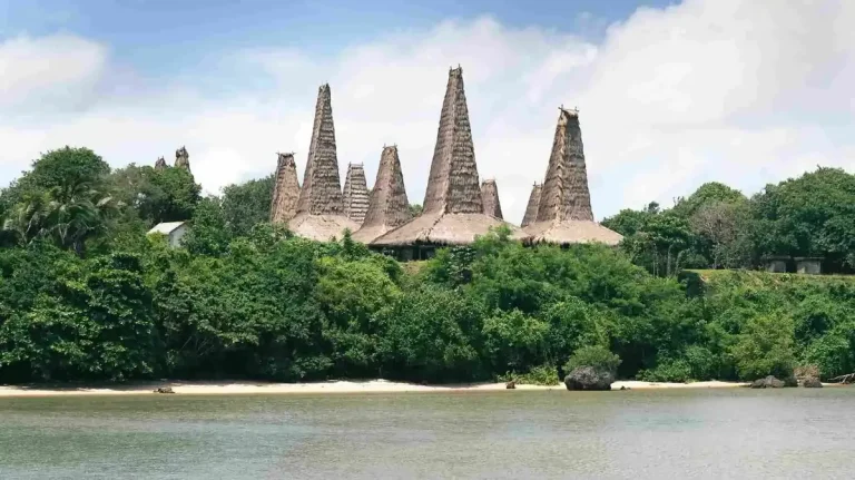 Traditional high-roofed village houses behind a shoreline