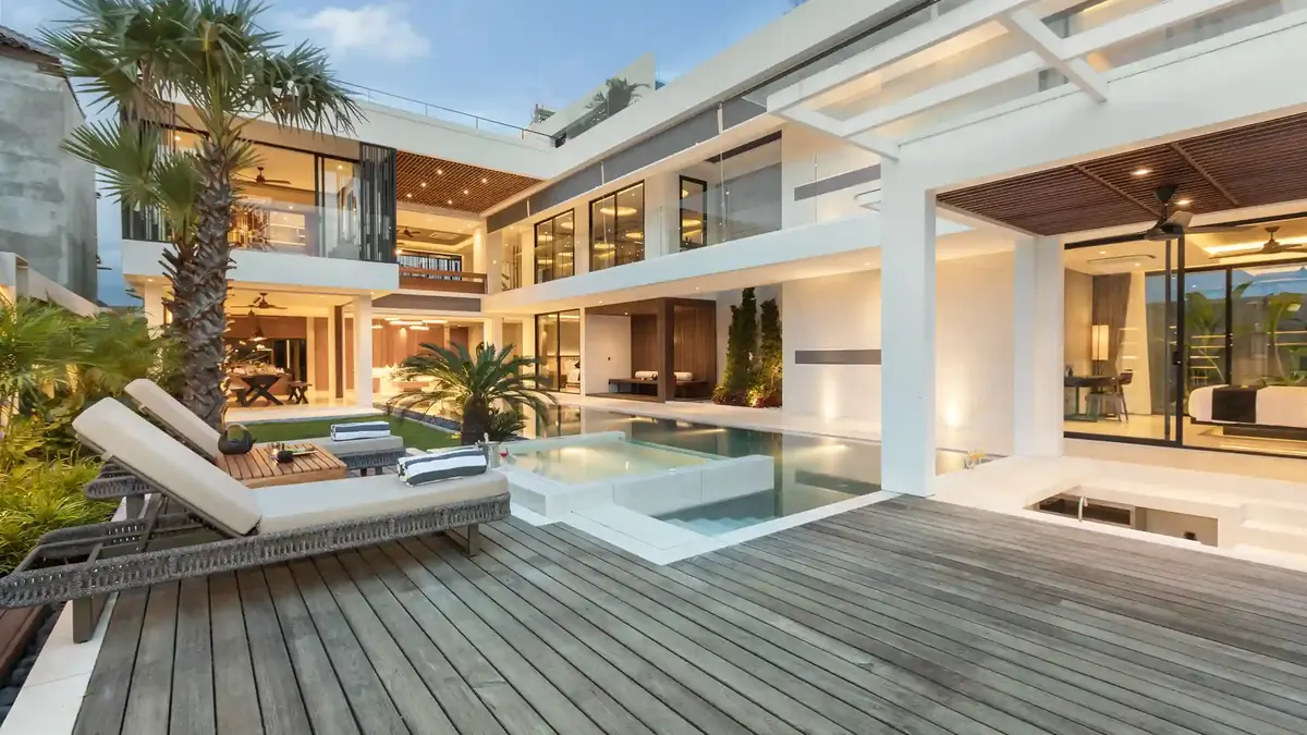 Villa terrace with loungers beside a pool at dusk