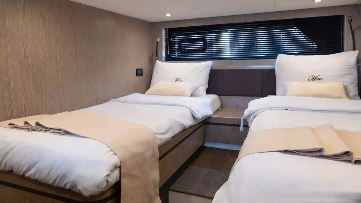 Guest cabin aboard a phinisi, timber panelling and made-up beds