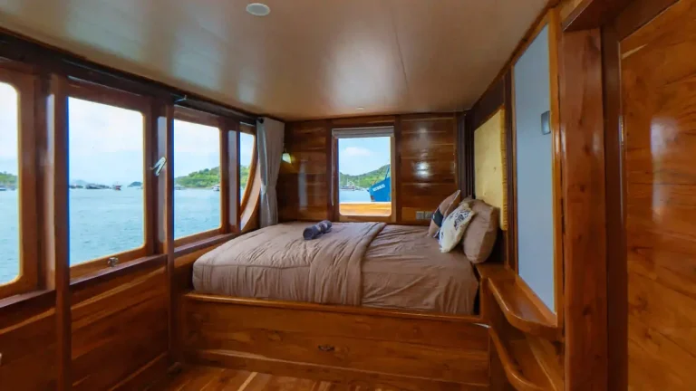 Guest cabin aboard a phinisi, timber panelling and made-up beds