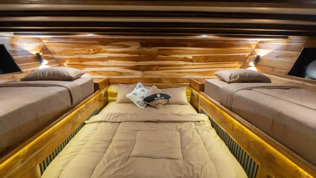Guest cabin aboard a phinisi, timber panelling and made-up beds
