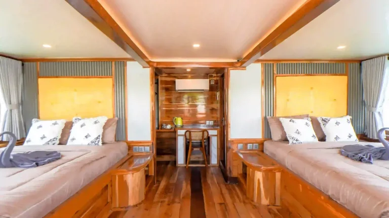Guest cabin aboard a phinisi, timber panelling and made-up beds