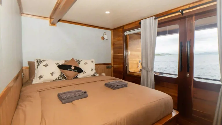 Guest cabin aboard a phinisi, timber panelling and made-up beds