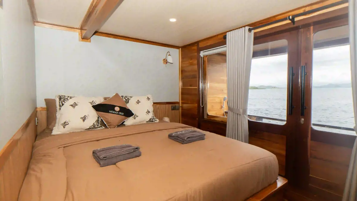 Guest cabin aboard a phinisi, timber panelling and made-up beds